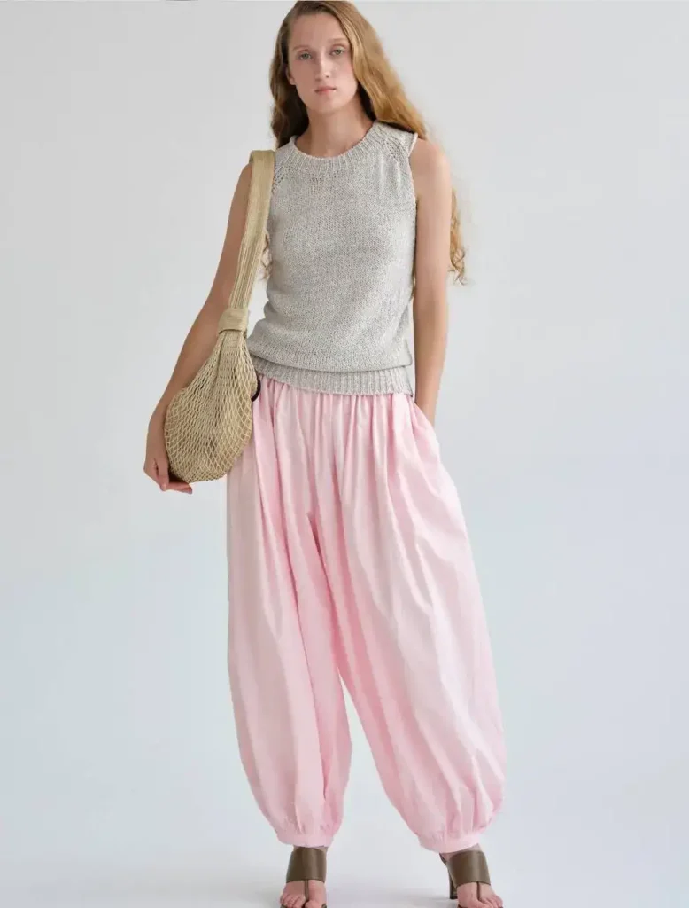Balloon pants paired with a casual knit top and a woven bag, blending comfort and style.