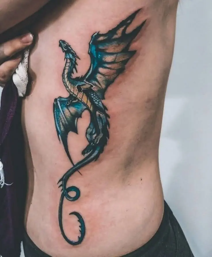 Blue dragon tattoo with spread wings on a torso.