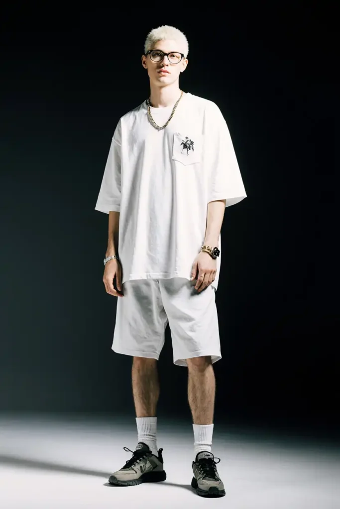 Street style trend featuring a man in a white oversized T-shirt, shorts, and sneakers.