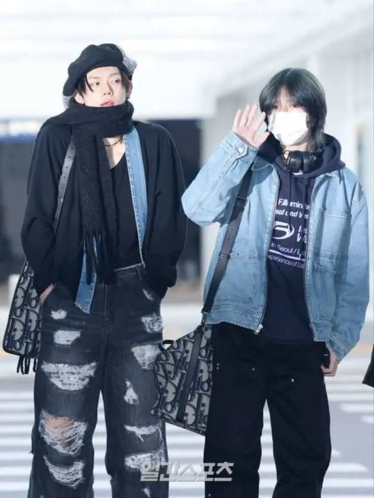 2 kpop singers on airport wearing stylish outfits.