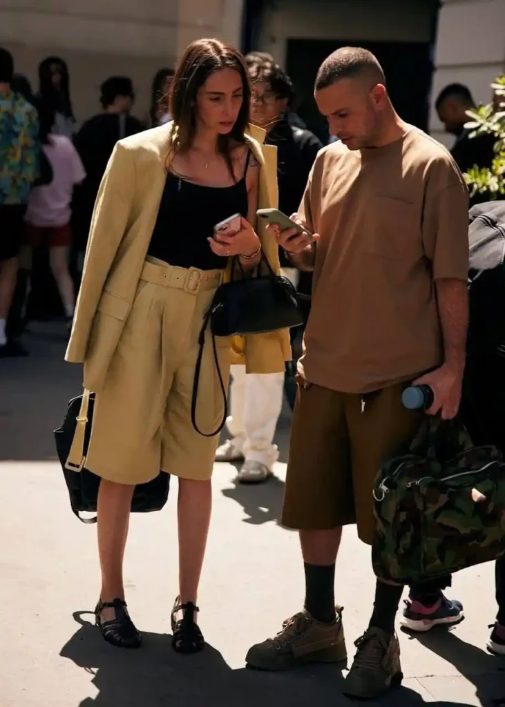 Bermuda shorts paired with a beige blazer, creating a stylish yet comfortable look for both men and women.