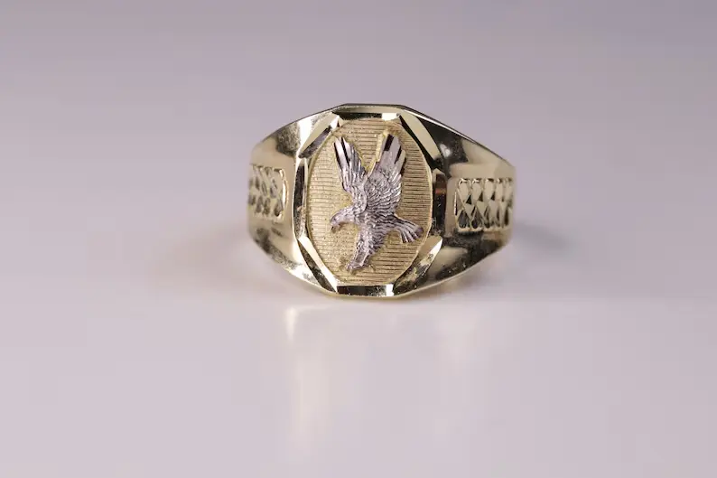 A gold bold ring on a flat surface.