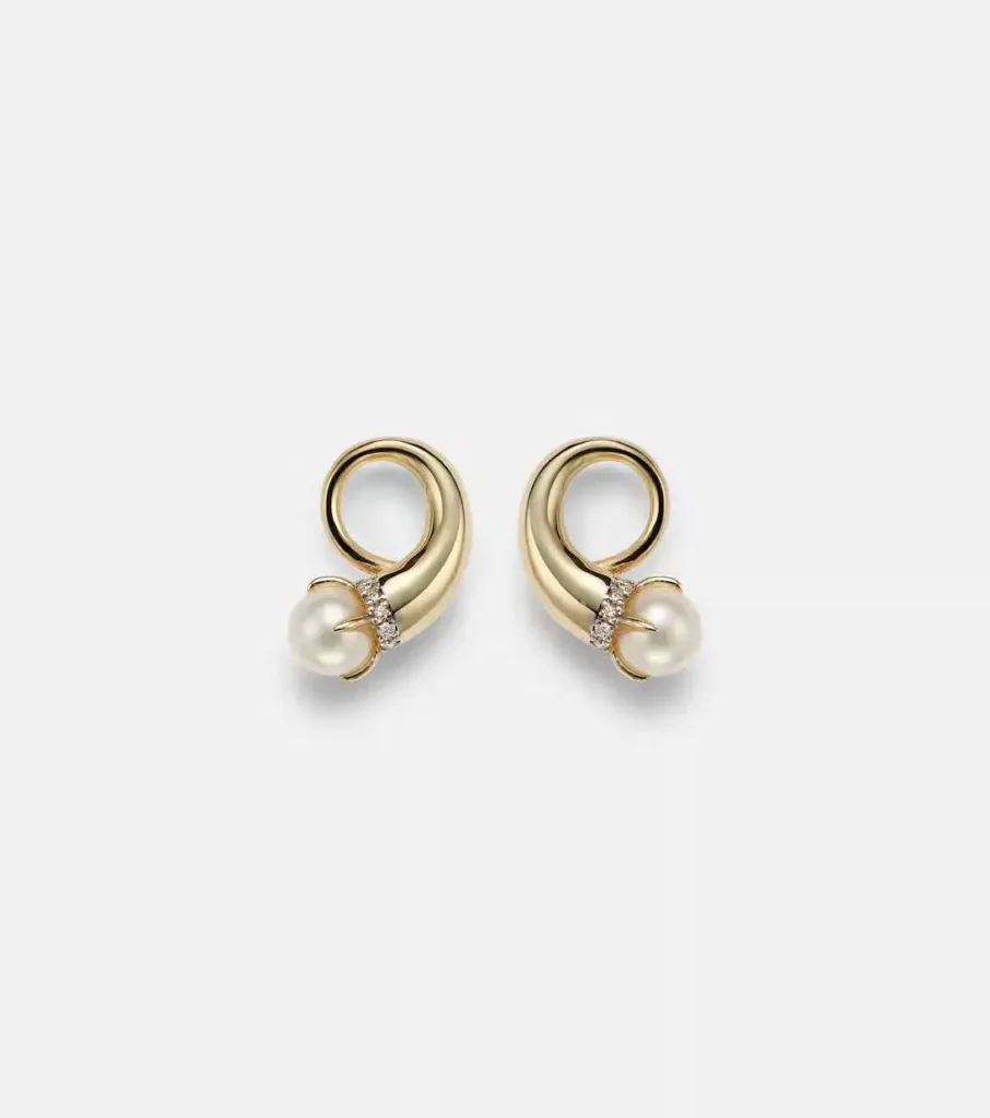 a set of pearl earrings on a flat surface.