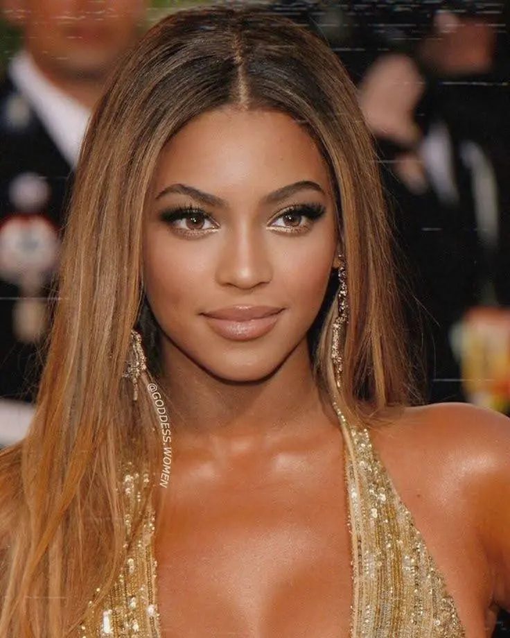 A close-up of Beyoncé, showcasing her celebrity face shape, with a confident smile and glamorous makeup.