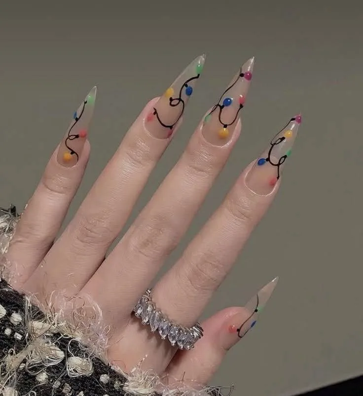A female hand showing long nails with gingerbread Christmas nail art.