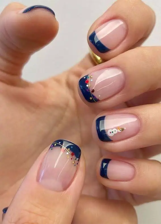 A female hand showing French tip gingerbread nail art in blue color.