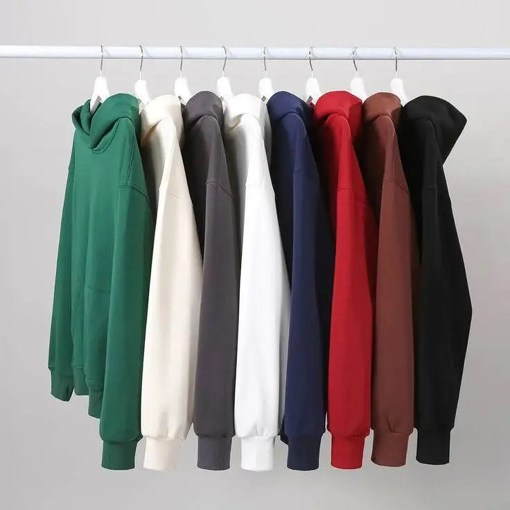 A row of hoodies in different colors hangs neatly on a white clothing rack.