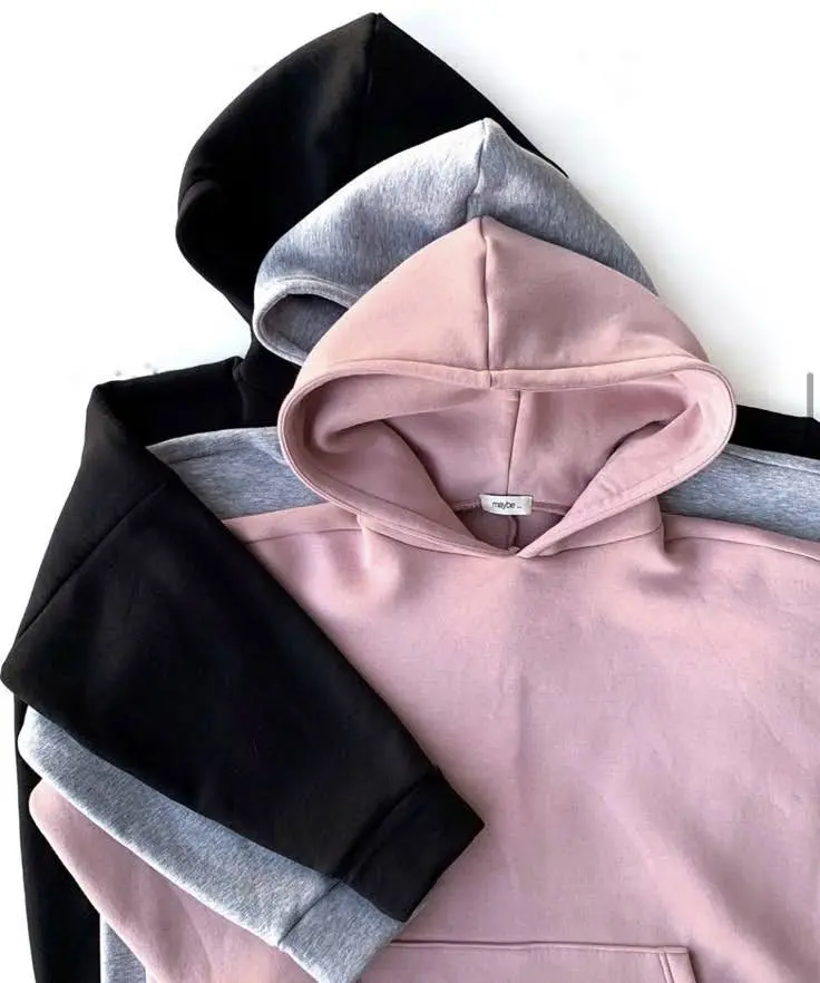 A stack of three neatly folded hoodies in black, gray, and pink.