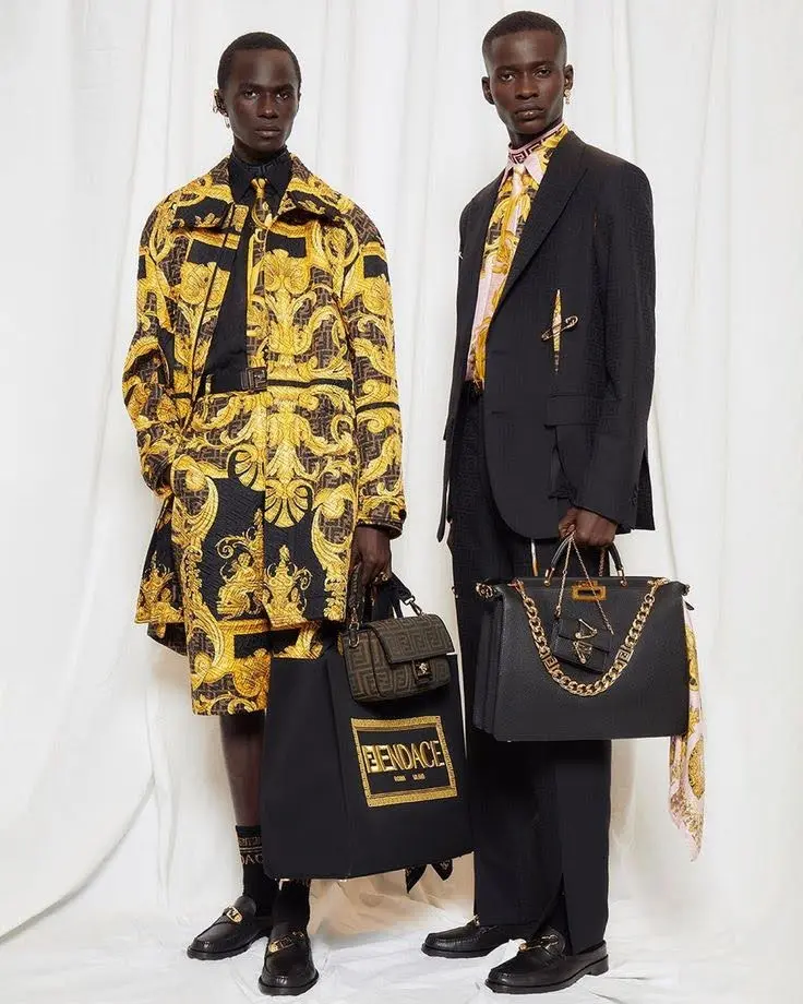 two runway male models wearing loud brand dress and having bold logo bags in hand.