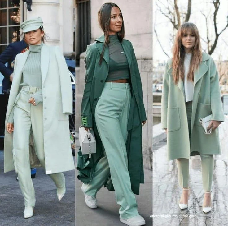 Three women wearing different monochrome green outfits, including coats, pants, and tops.