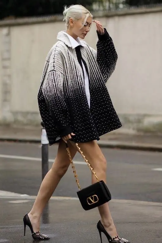 A female model with a bold logo bag and a branded dress.