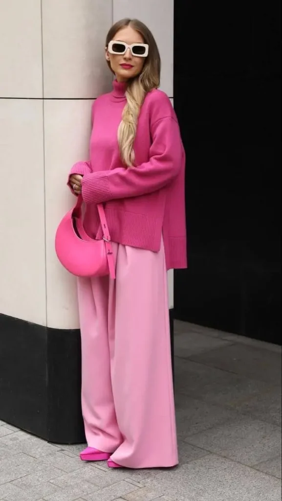 A person wearing a head-to-toe pink outfit with a pink blazer, shorts, and shoes.