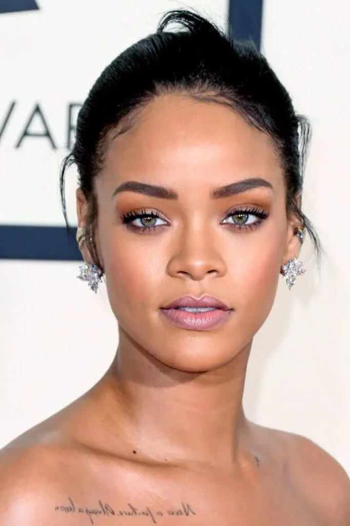 A close-up of Rihanna, a celebrity with a diamond face shape, with a confident expression.