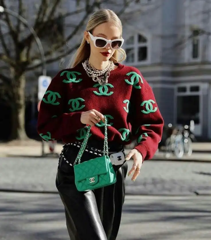 A smart girl bold logo shirt and holding a branded bag in her hands .
