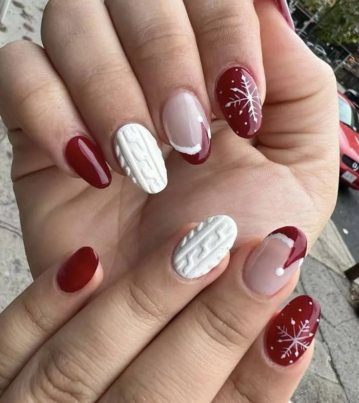 A female hand showing nails with snowflake nail art.