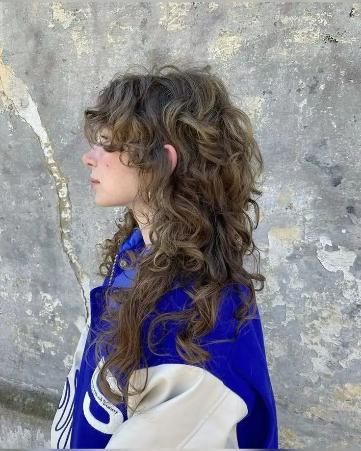 A girl showing a stylish curly wolf cut hair style.