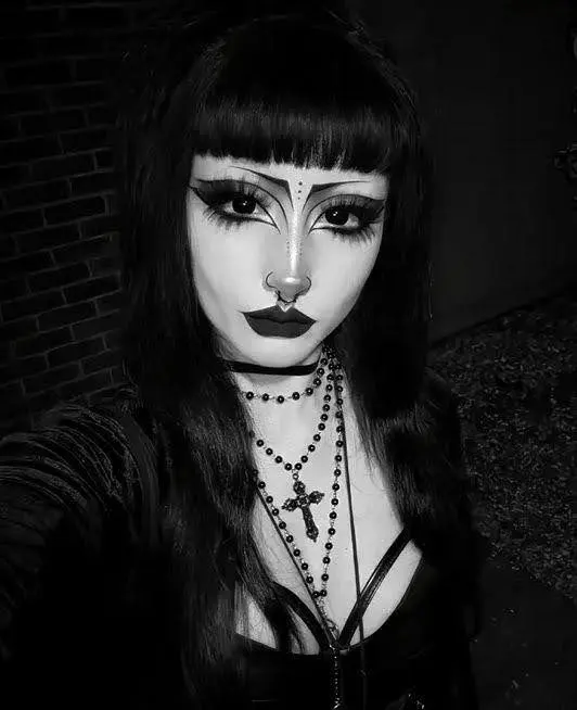 a girl showing her dark trad goth makeup