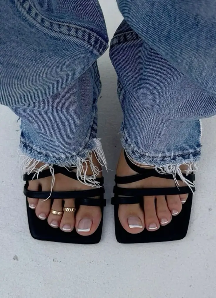 A girl wears 2 rings on feet fingures.