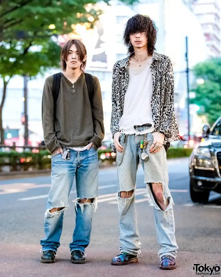 2 mans showing 2000s grunge fashion look standing in a open place