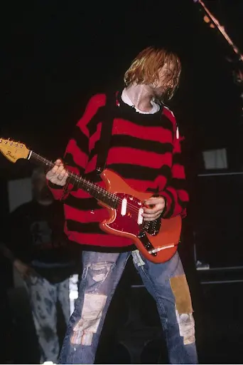 Kurt cobin in a concert with a guitar
