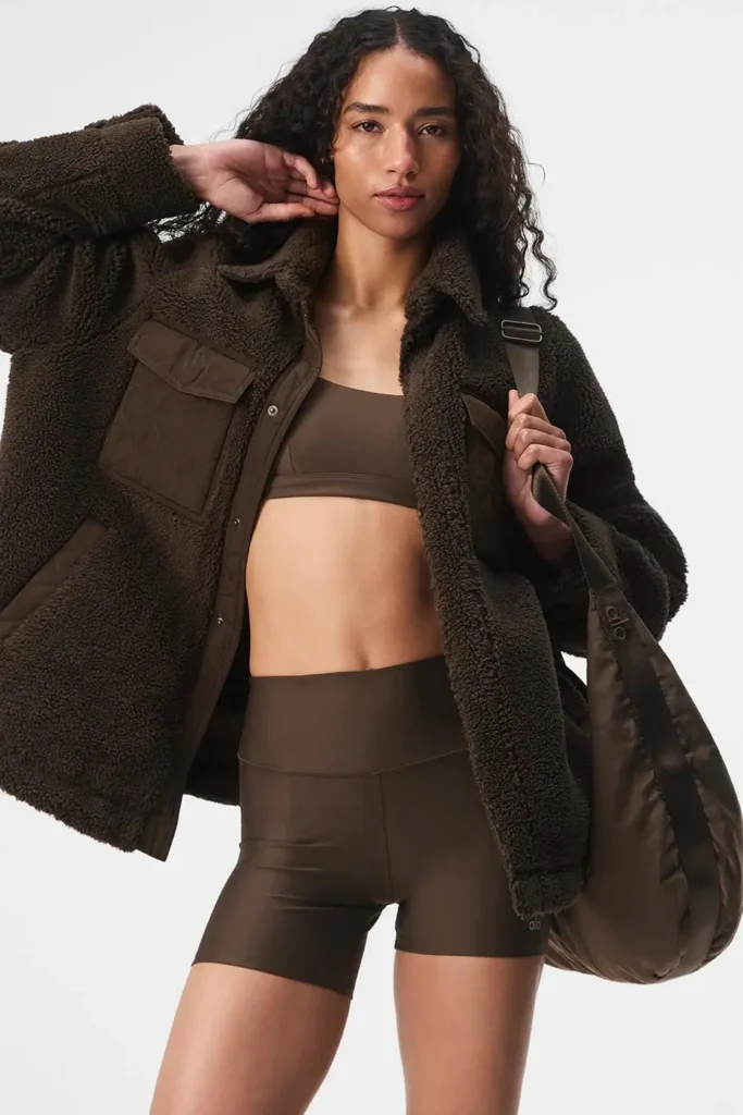 a girl with brown coat bag , and shorts