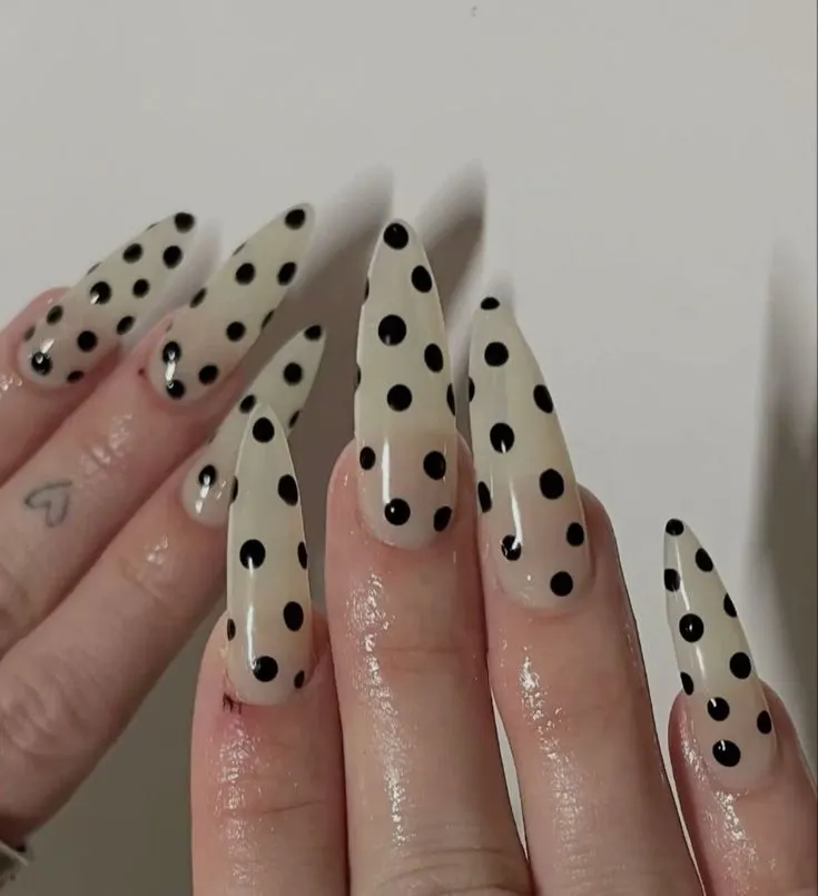 a girl showing 2 hands with polka dot nail oval shapes