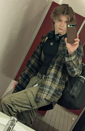 A boy is with phone taking mirror selfie