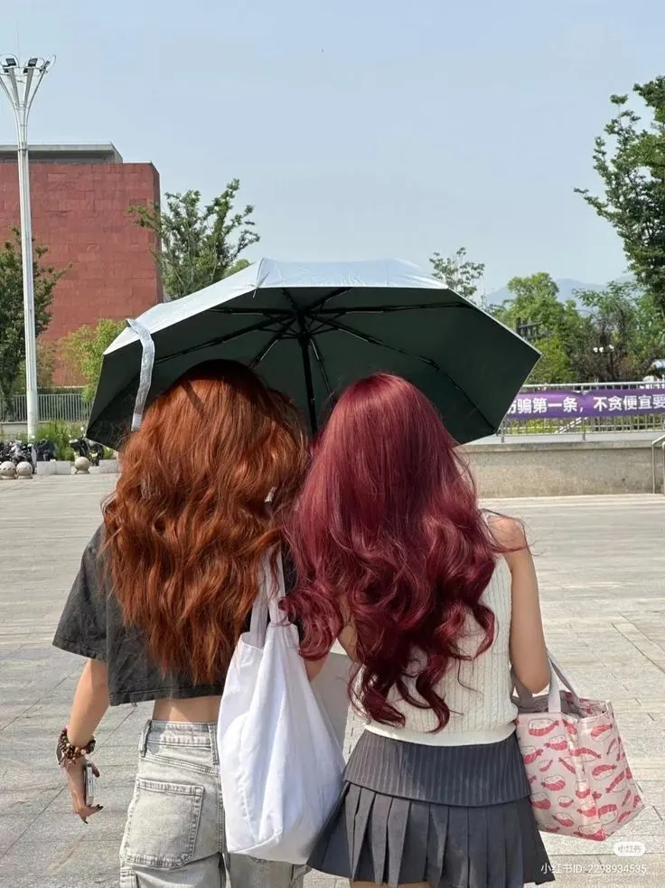 2 girls back view showing 2 different hair cherry red and brown