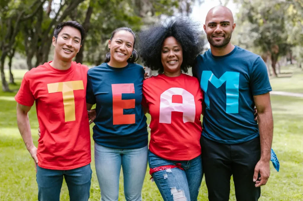 Group of people wearing matching shirts that spell “TEAM,” symbolizing unity, collaboration, and the power of coordinated team clothing.