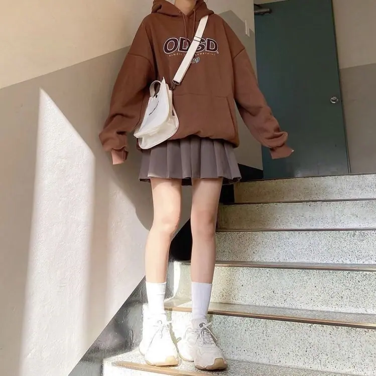 a girl wearig a oversized hoodie with skirt