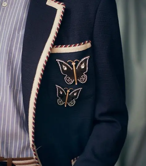 a men wearing branded butterfly brooches on a blazer