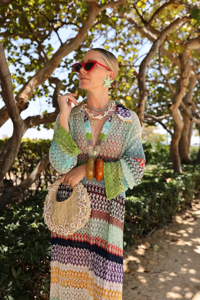 a girl wearing handmade dress and jwellery and hlding handcrafted bag