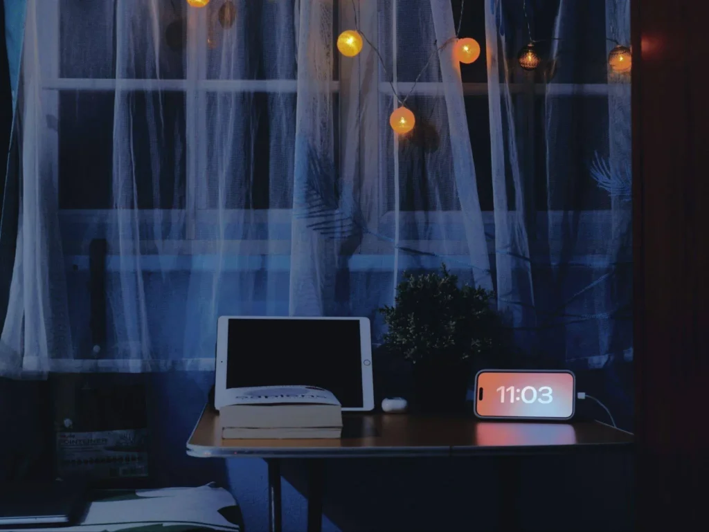 Woman relaxing in a softly lit modern living room during a peaceful nighttime routine with warm lighting and cozy home decor