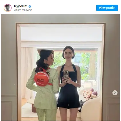 Lilly Collin is taking a mirror selfie with another girl