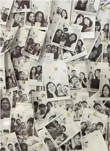 A wall covered in black-and-white photo strips of friends and couples