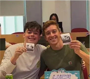 Two friends smiling and holding up their black-and-white photo prints