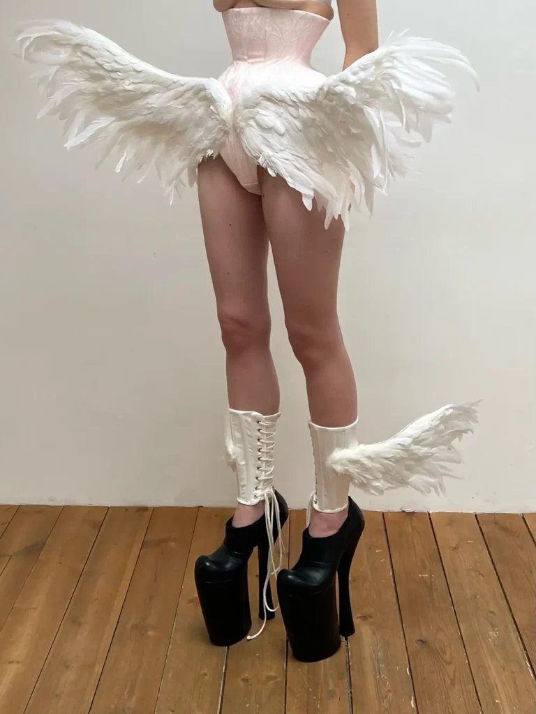 Ilya Migmoon wings on a women belly and upside of boots on legs